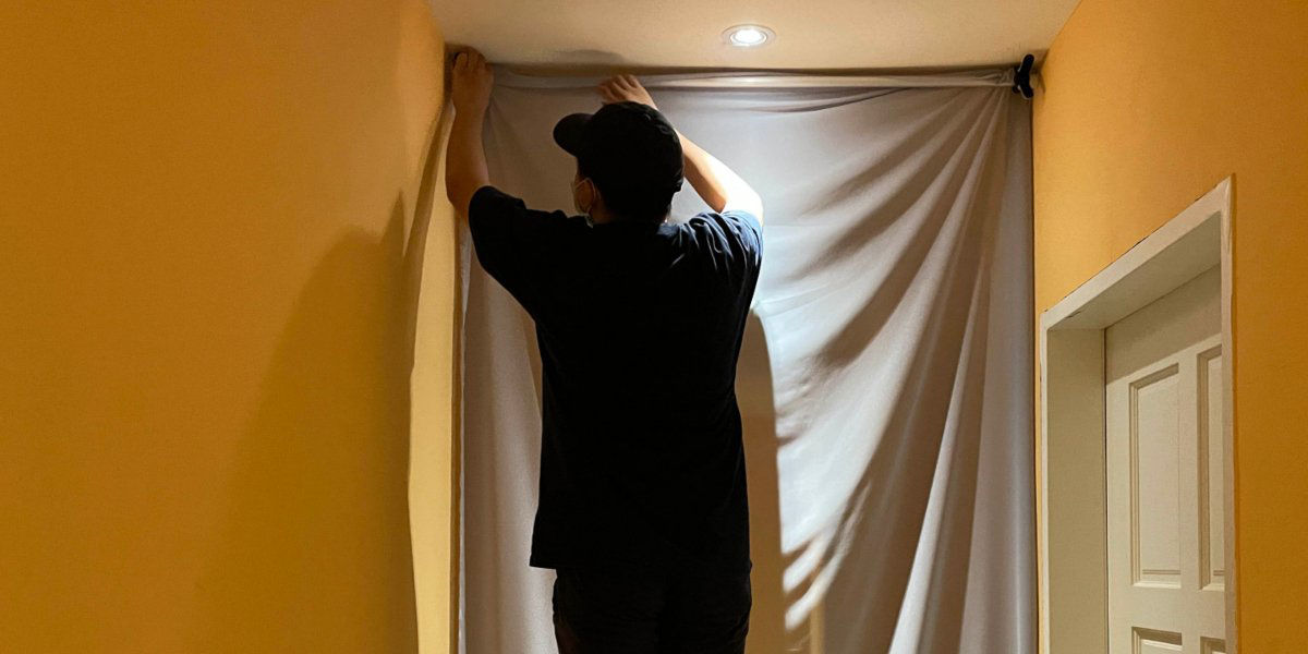 a man standing on a chair set up projector screen