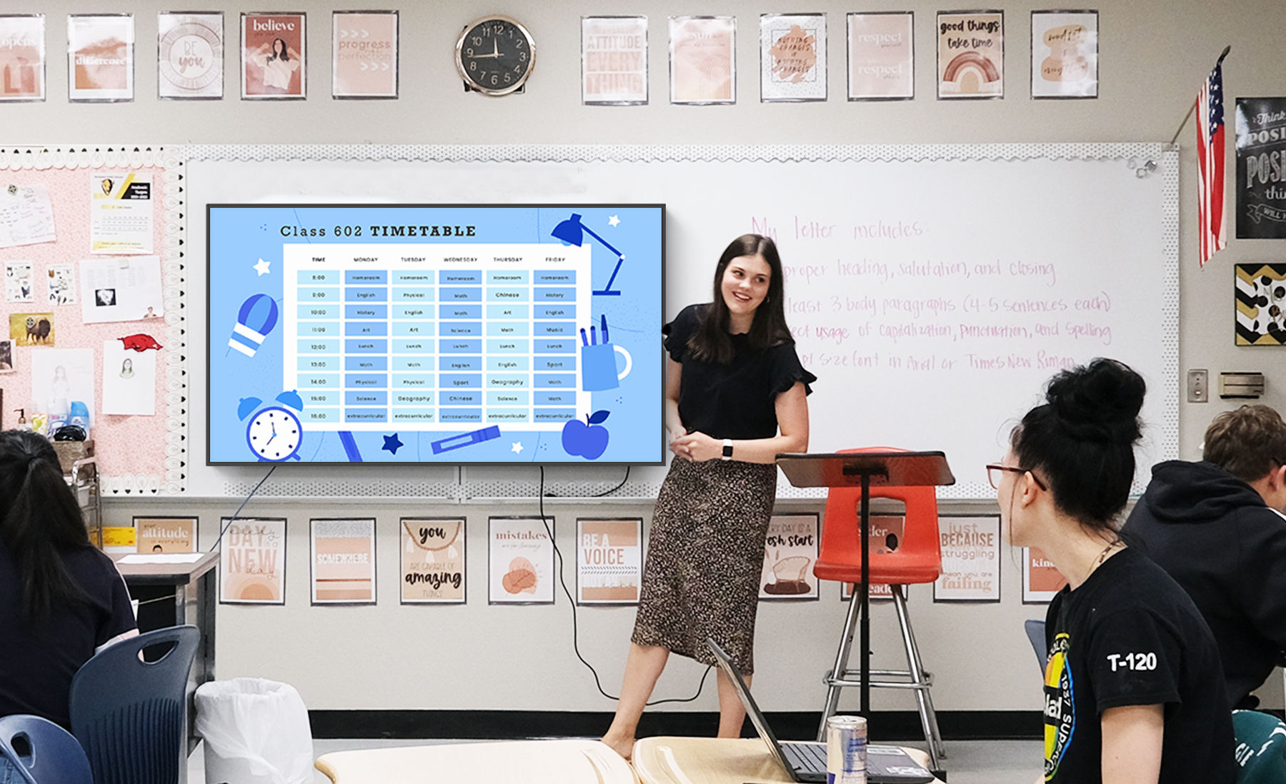 Teacher giving lesson in front of students with digital signage display showing timetable schedule