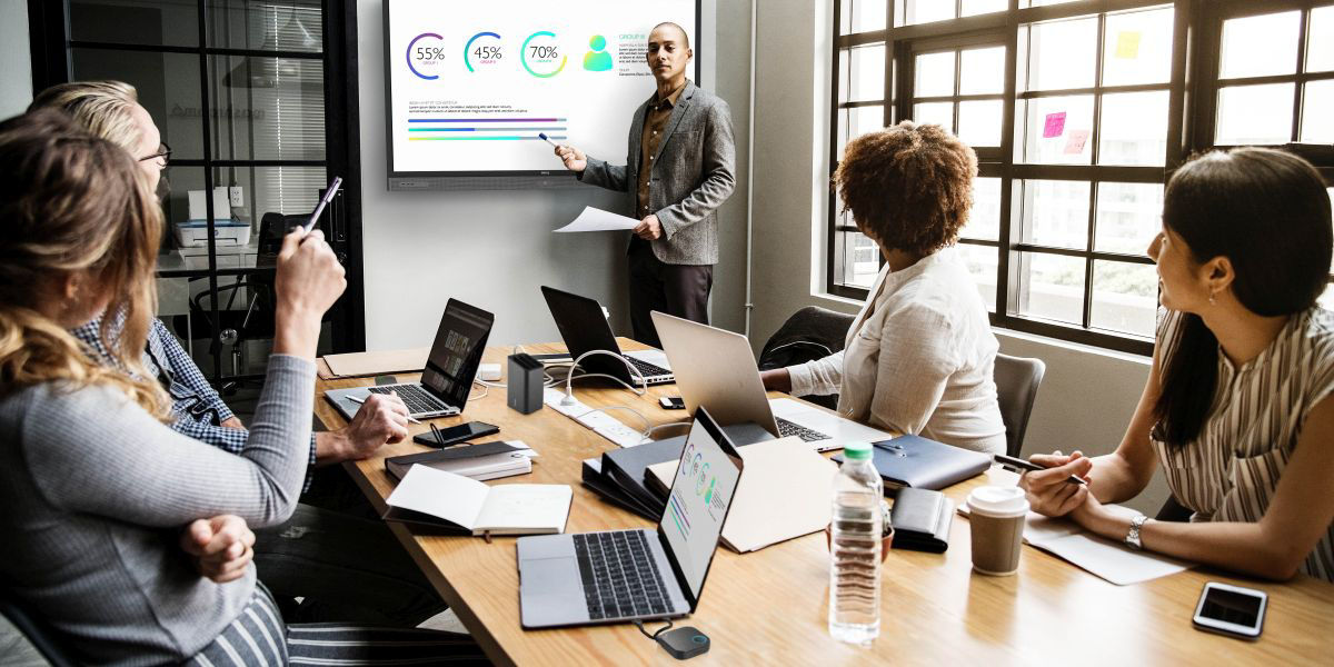 A group of people in a meeting room using wireless presentation system for collaboration