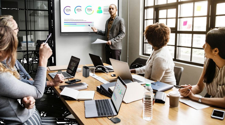 A group of people in a meeting room using wireless presentation system for collaboration