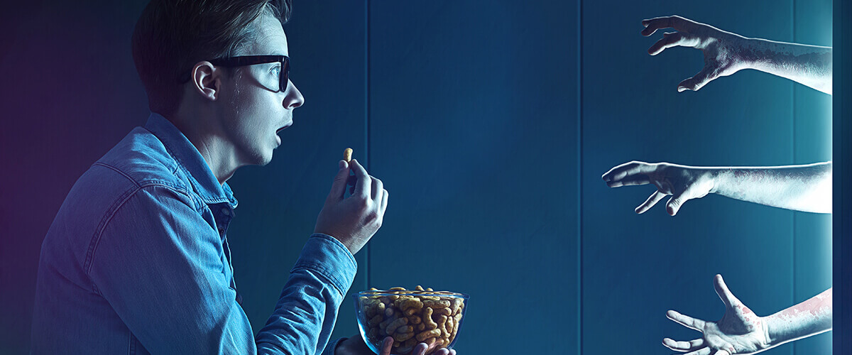 The man is frightened by the hands stretching from the monitor when eating.