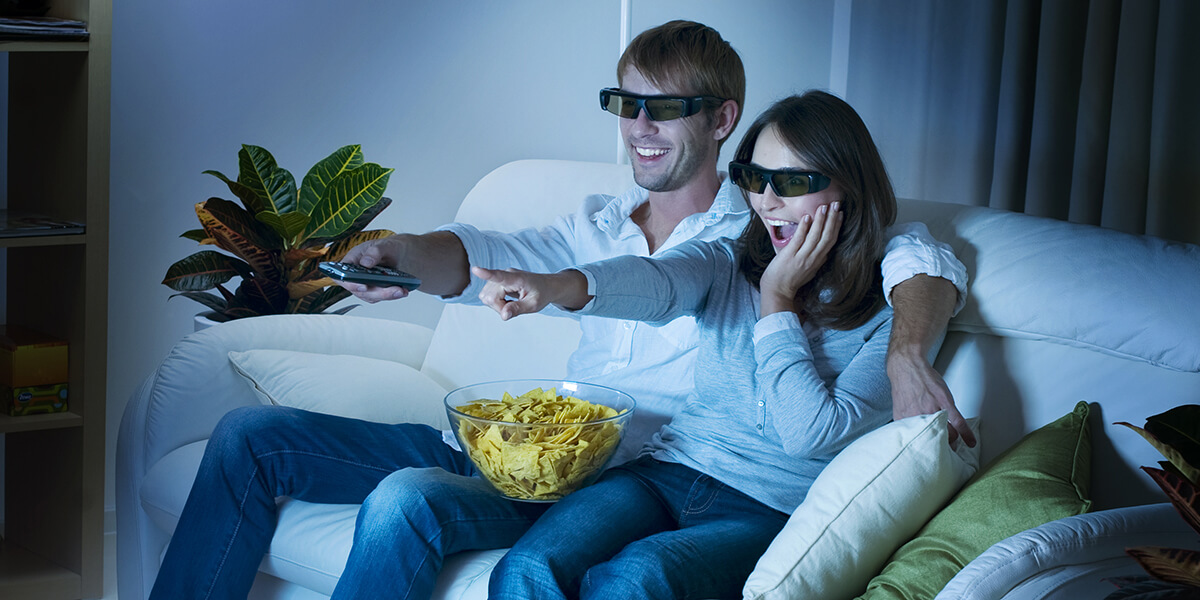 A couple is viewing high-quality 3D video with 3D glasses.