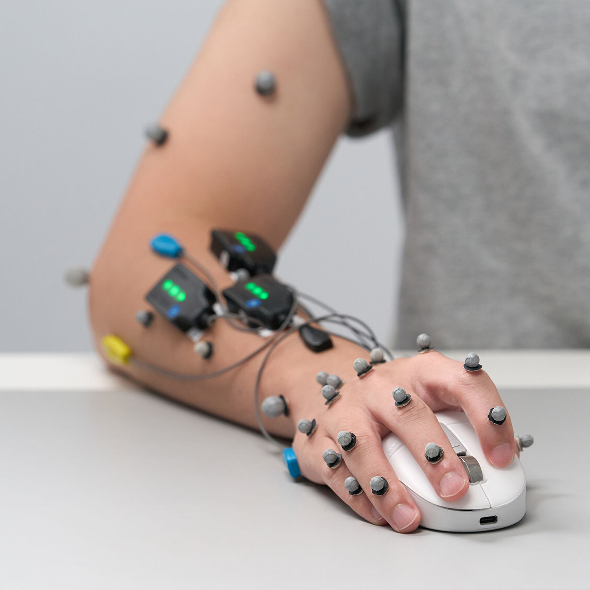 Hand using INFTYLAB M Mouse with sensors attached for ergonomic testing and hand movement analysis.