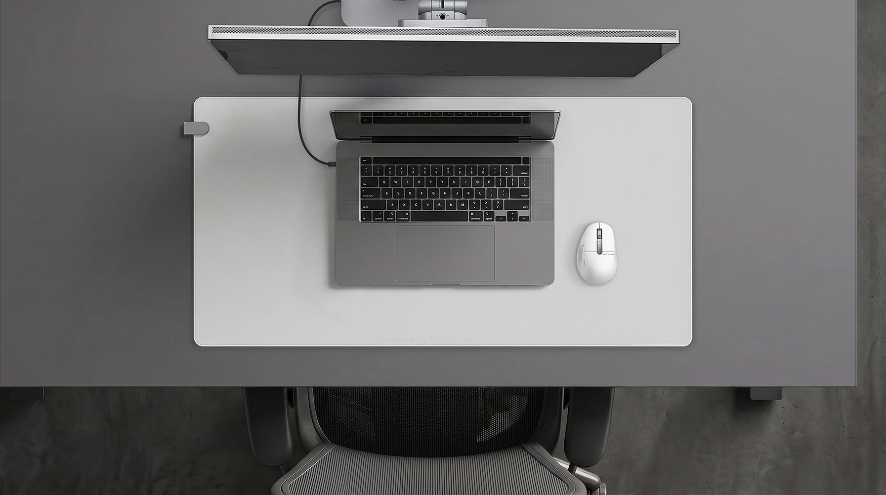 FLOW Desk Mat on a dark desk with MacBook Pro setup — laptop and mouse arranged on the mat surface
