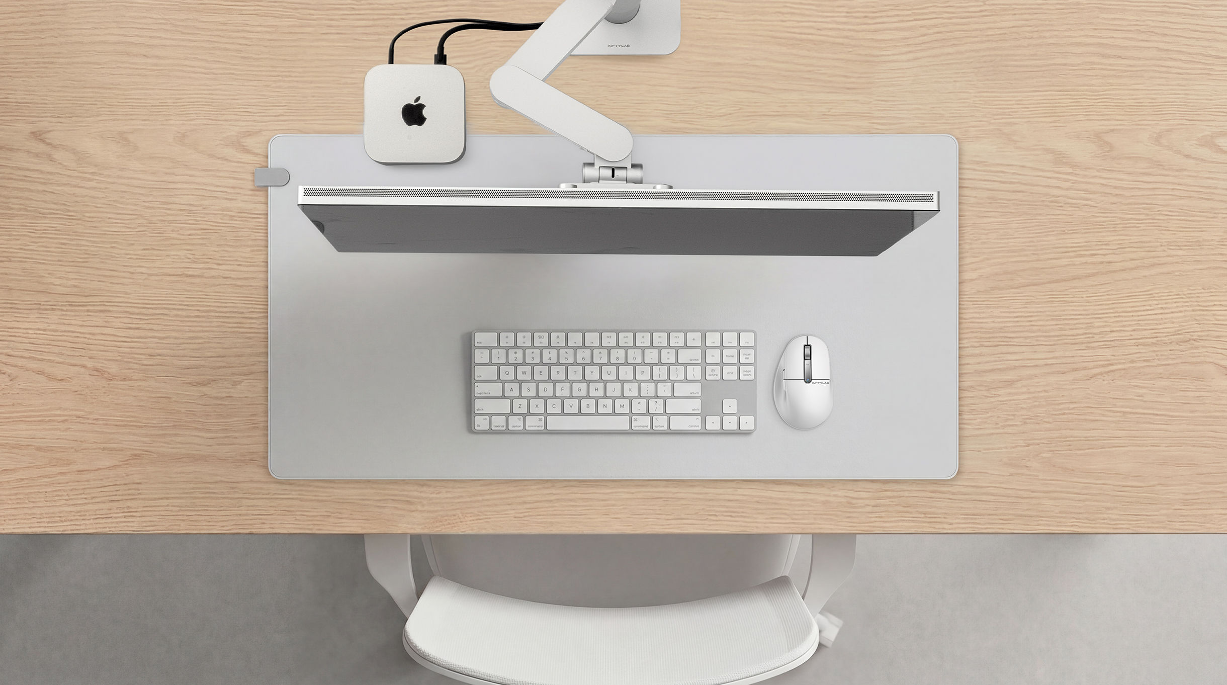 FLOW Desk Mat on a wooden desk with Mac mini setup — keyboard and mouse arranged on the mat surface