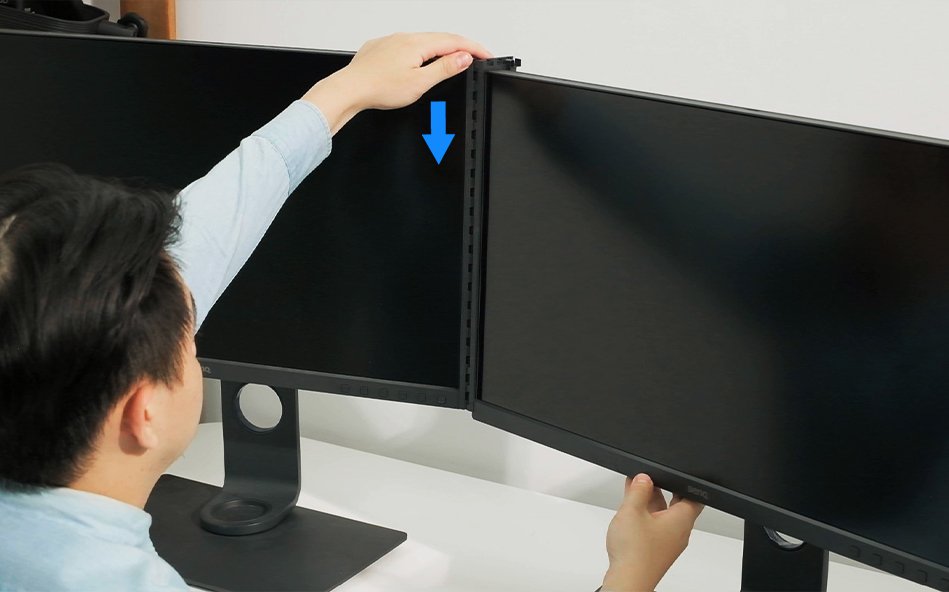 place one hand on the top of the left side monitor to keep it in place so that when you push the bridge upward