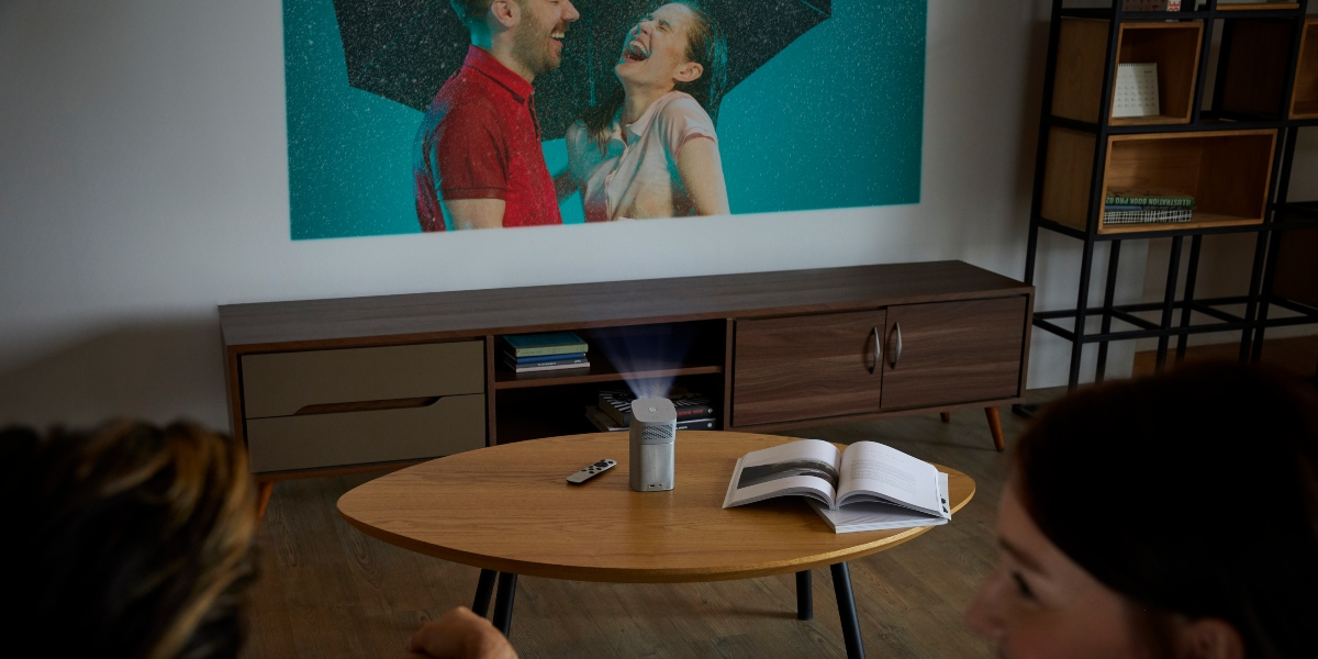 A portable projector GV1 displays  tv series on a white wall.