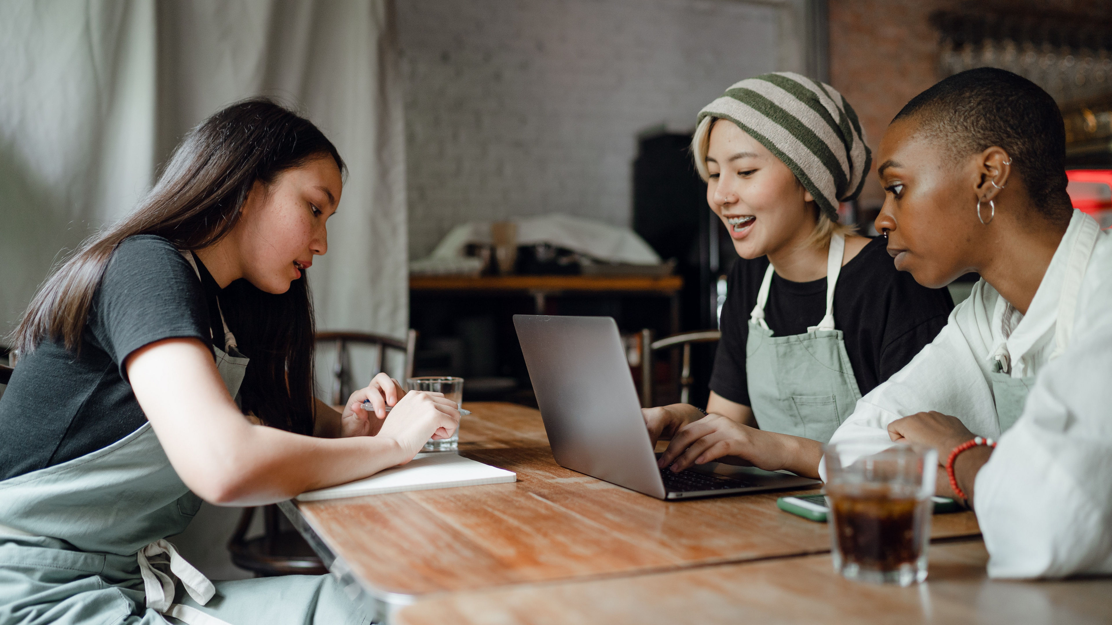 3 girls having a discussion in a cafe