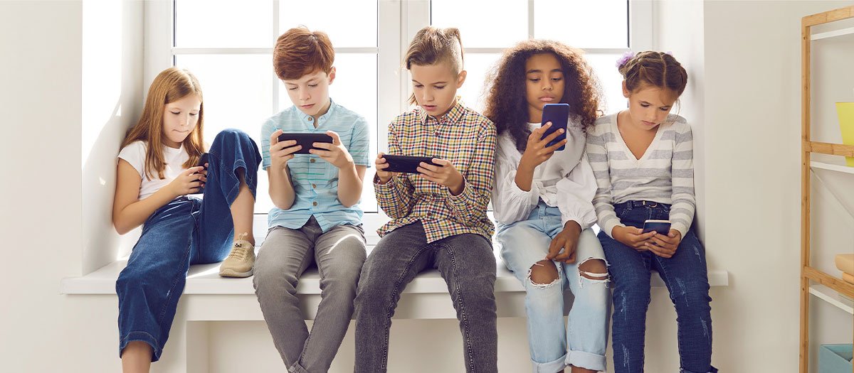 a group of alpha generation students playing on their smartphones during a break at school