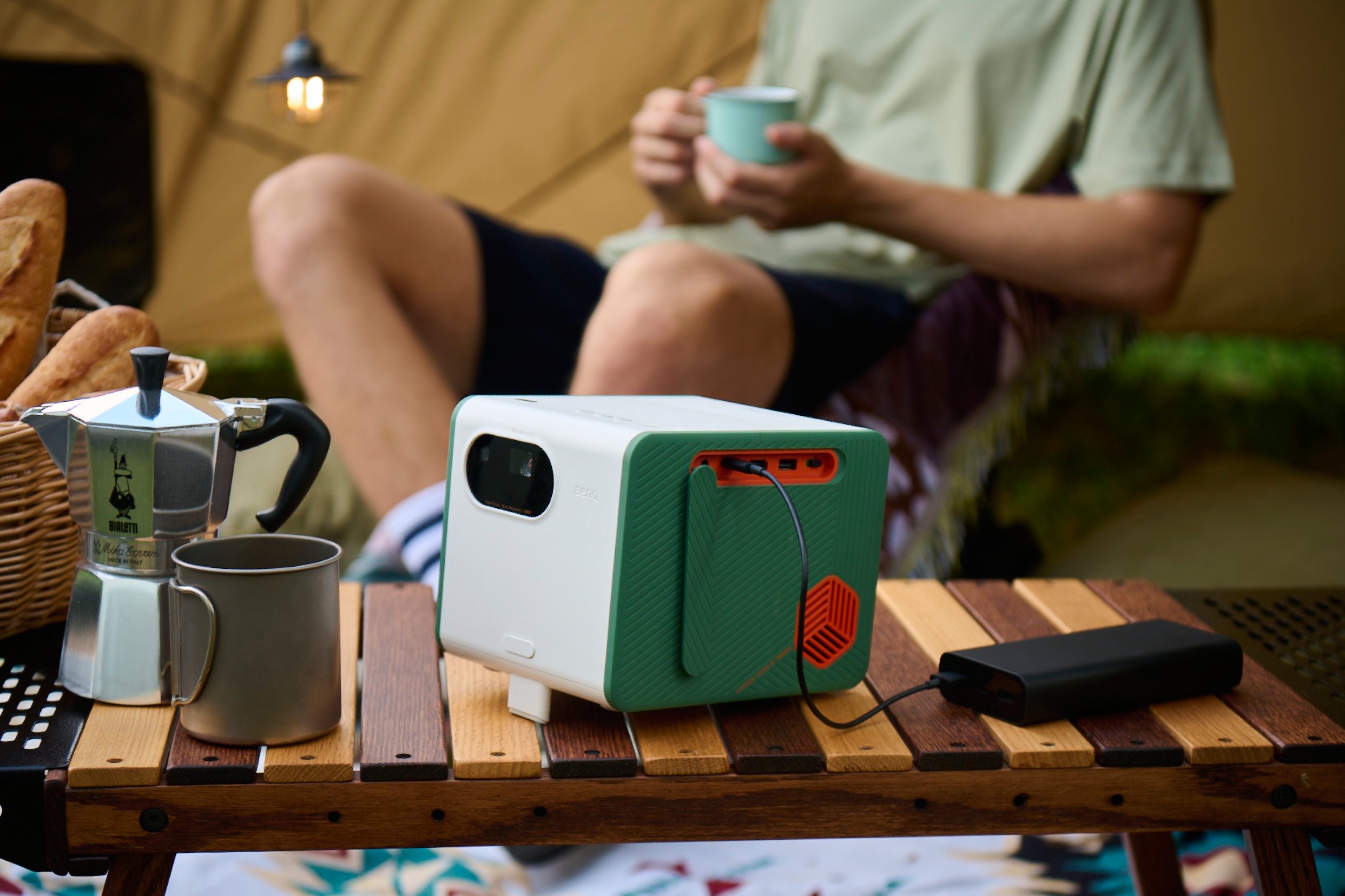 portable projector charging by a power bank at a campsite