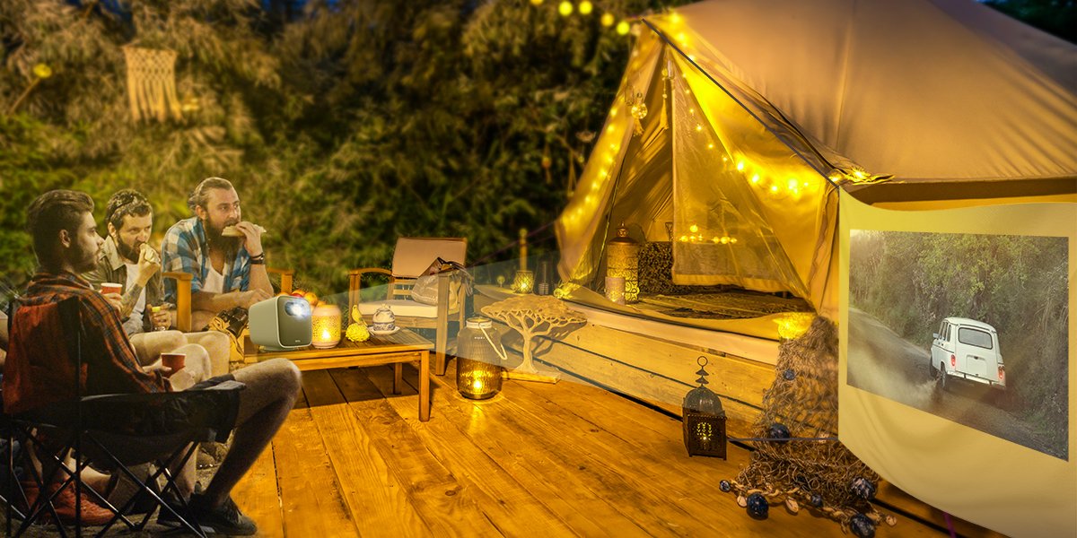 friends get together at a glamping site watching movies with a portable projector