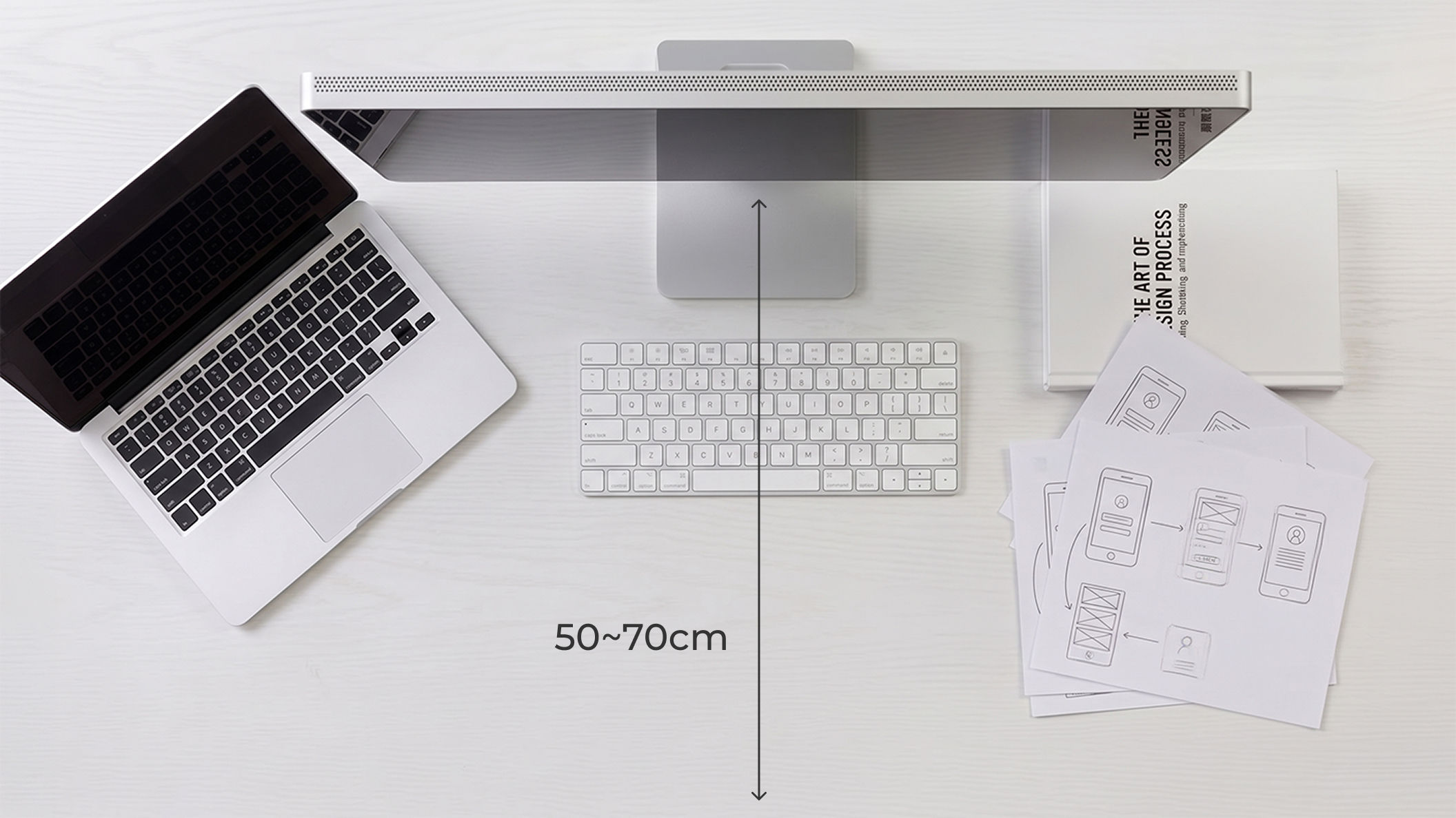 Top-down view of an Apple Studio Display and the recommended 50–70 cm viewing distance.
