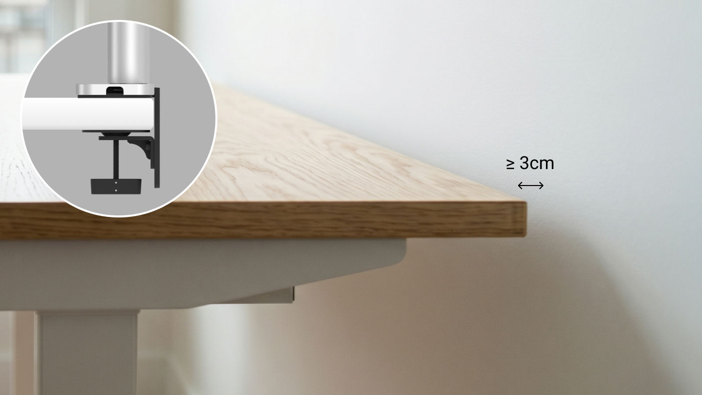 Illustration showing that a monitor arm clamp requires at least 5 cm of clearance behind the desk for installation.