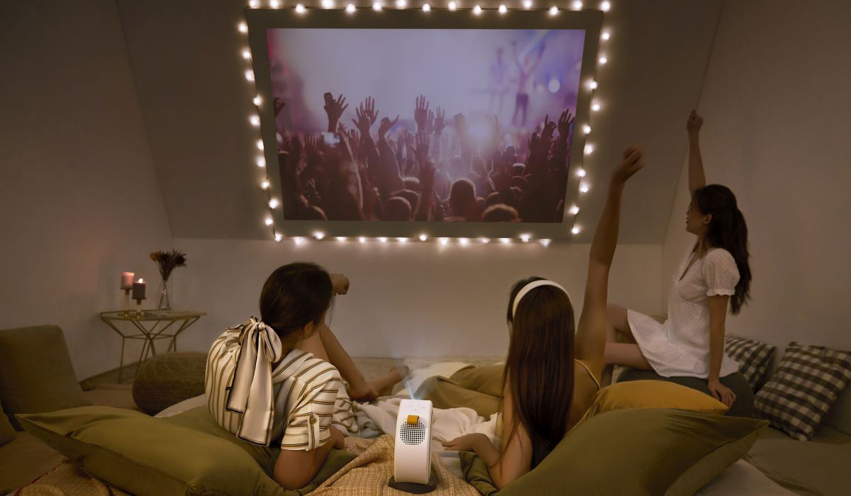 Young  girls watching movies on a slented wall using GV30 portable projector