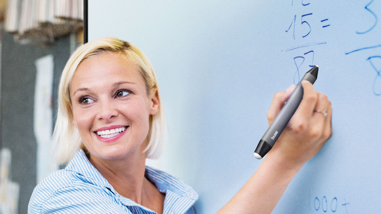 Lehrer schreibt vor der Klasse auf der BenQ-Tafel