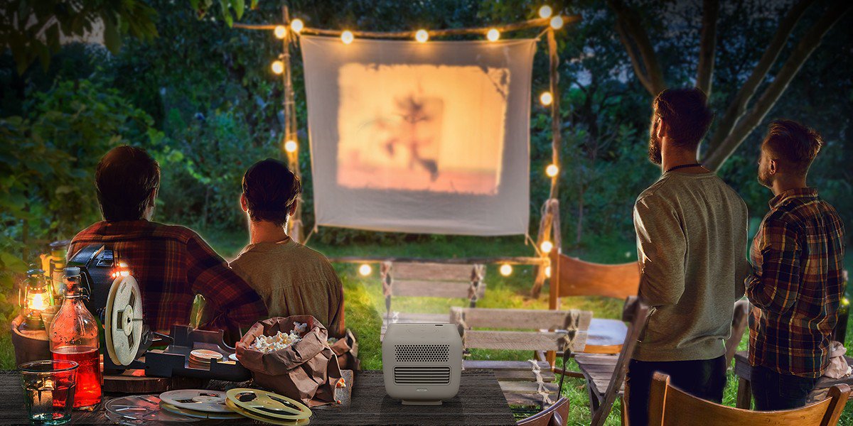There are four friends gathering in the backyard and enjoying outdoor cinema with a portable projector GS2.