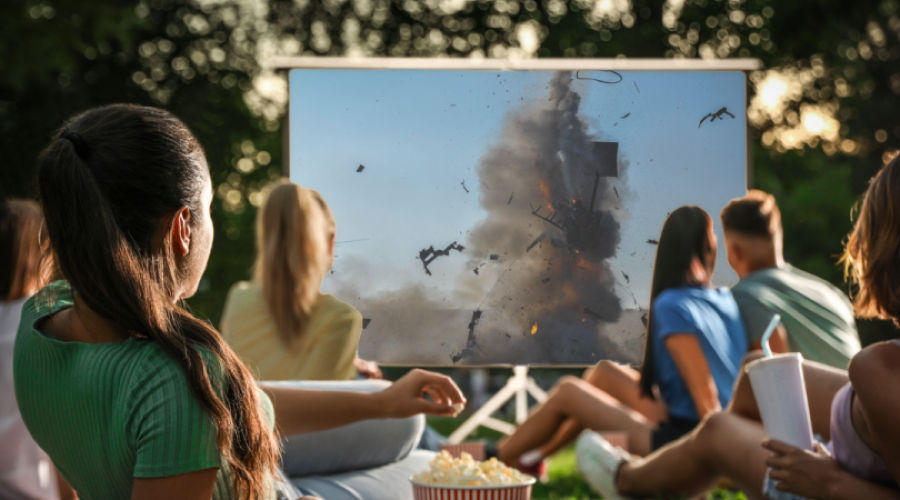 A couple preparing to watch movies on a projector in the backyard 