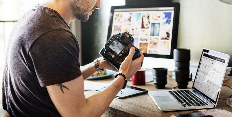 The photographer is going to edit the photo with his monitor, camera and laptop.