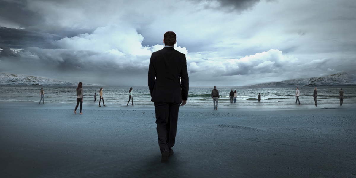 A man wearing a suit is standing on the beach.