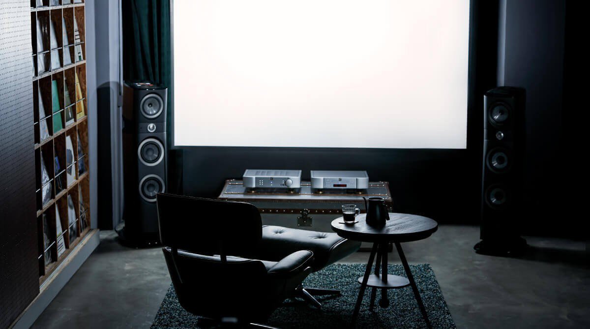 The projector placed on the desk is close to the large projection screen.