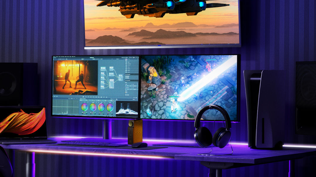 A three-monitor setup with BenQ Hybrid Dock DP1310 showing laptop output and gaming console switching.