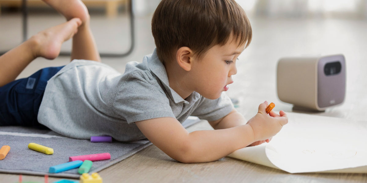 a kid at home drawing witha portable projector for edutainment at home