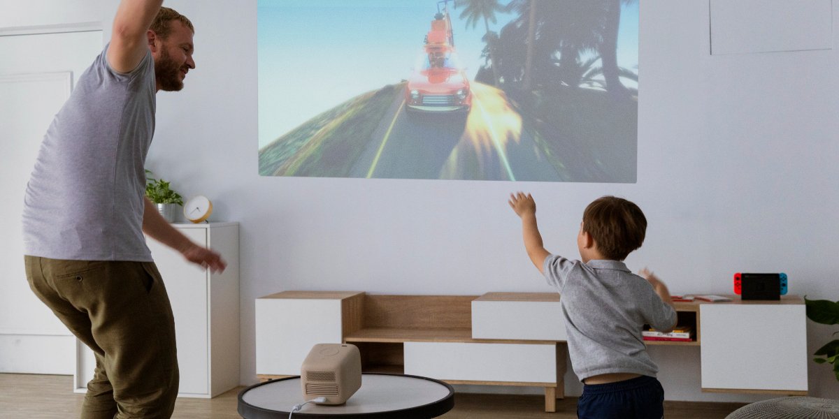 a father and his son playing entertainment at home on a portable projector for edutainment