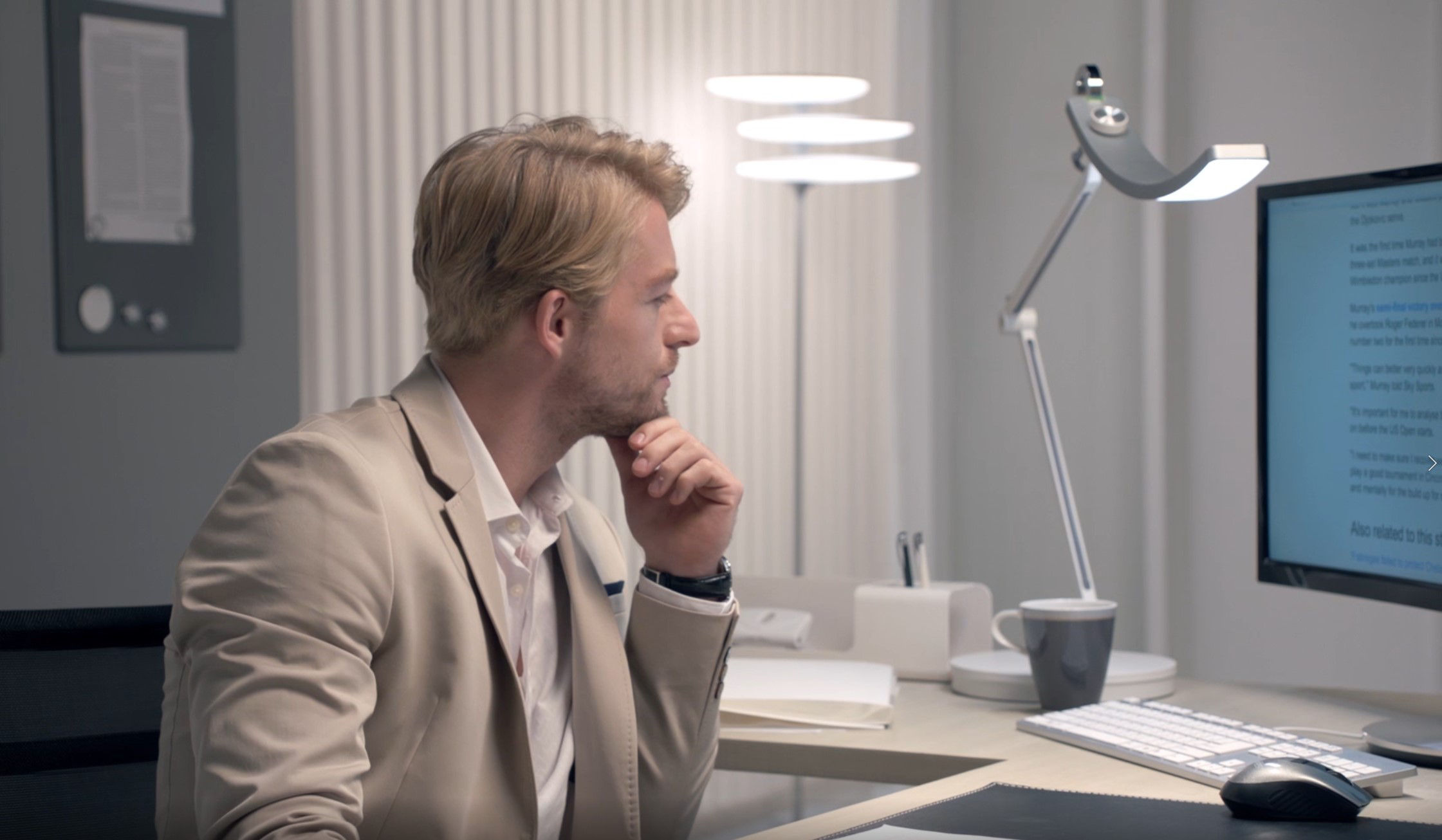 business man staring at the screen with BenQ e-Reading Desk Lamp on the desk