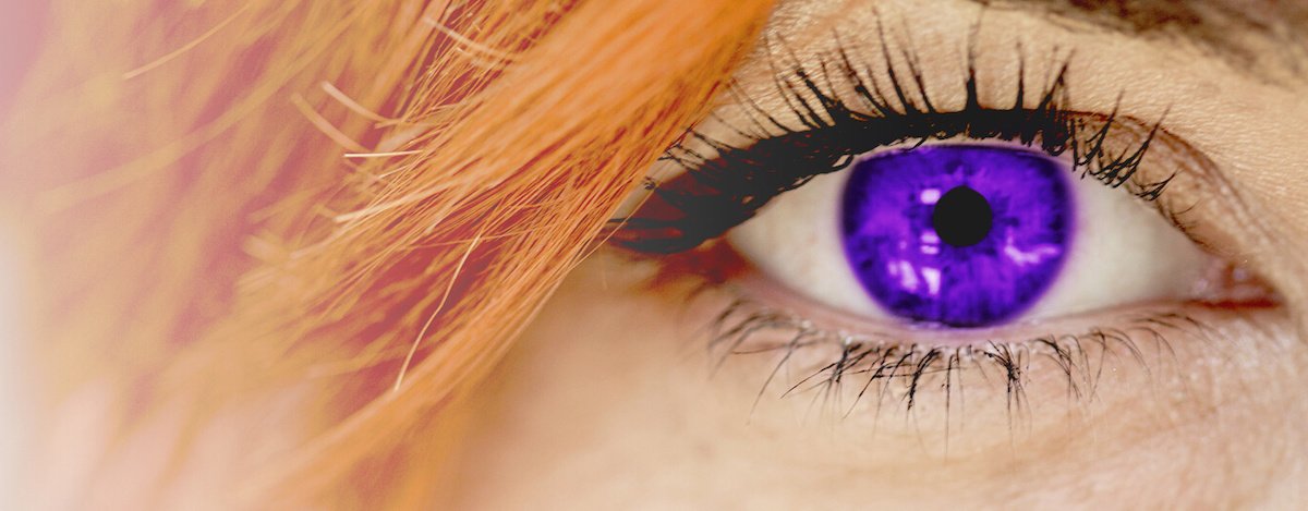There is a  woman opening her purple eye.