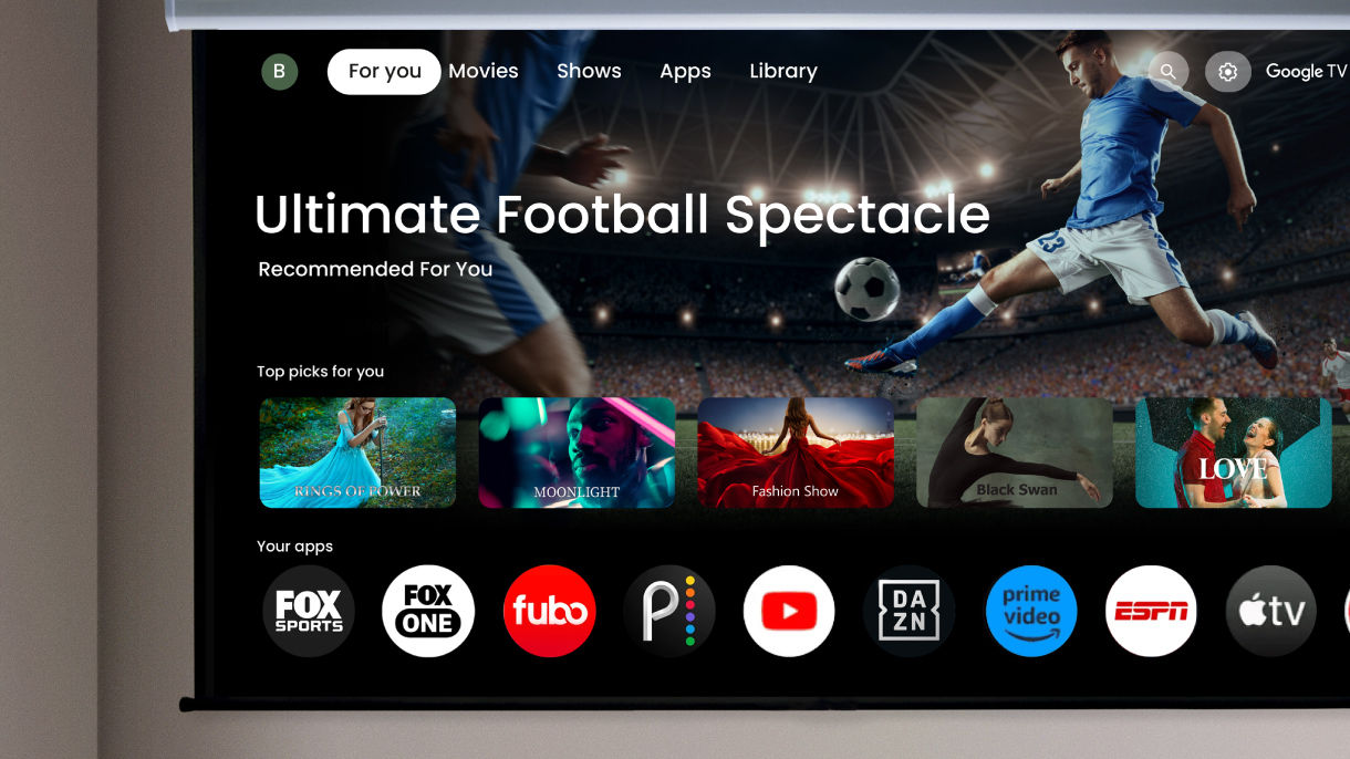 Projektor BenQ do kina domowego z wbudowanym Google TV, wyświetlający interfejs streamingu sportu z aplikacjami takimi jak FOX Sports do oglądania meczów piłki nożnej.