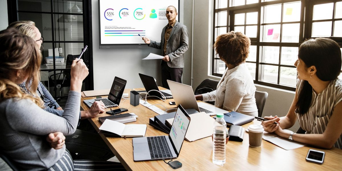 A group of people are using wireless presentation system for the conference in a meeting room.