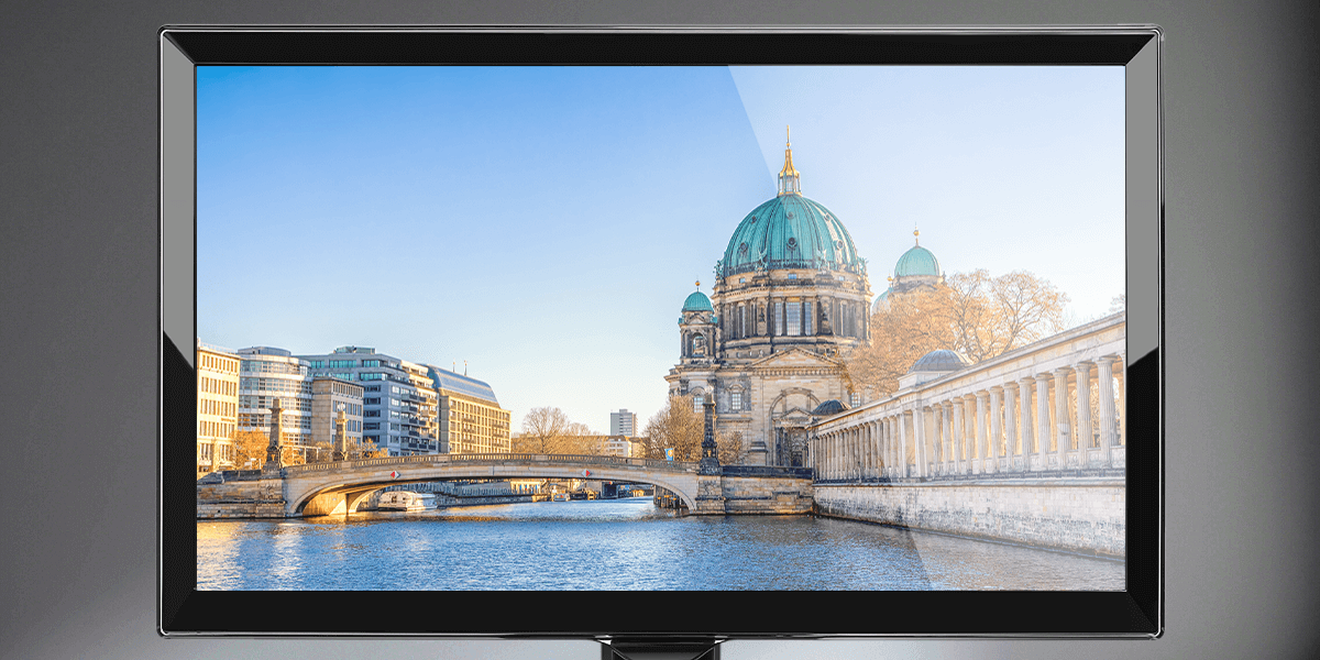 glossy monitor screen shows a cathedral by a river