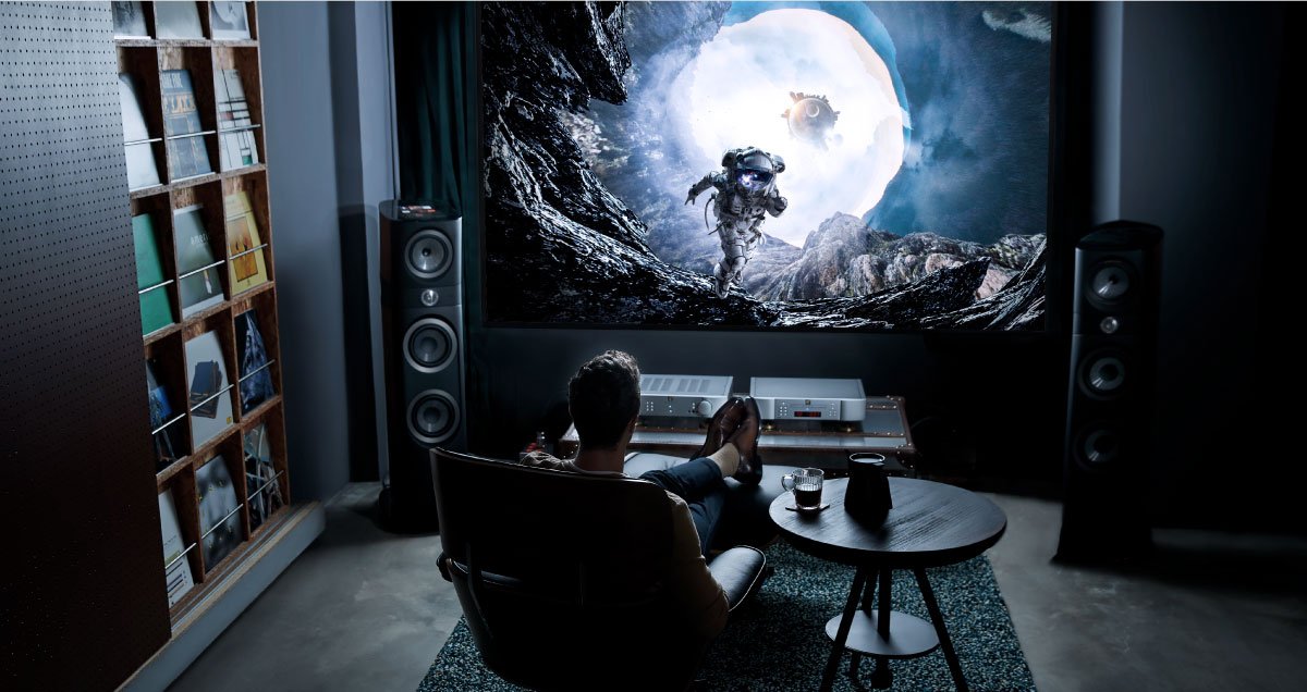 Mann schaut HDR-Filme auf einem geeigneten Player und Soundsystem in seinem Heimkino.