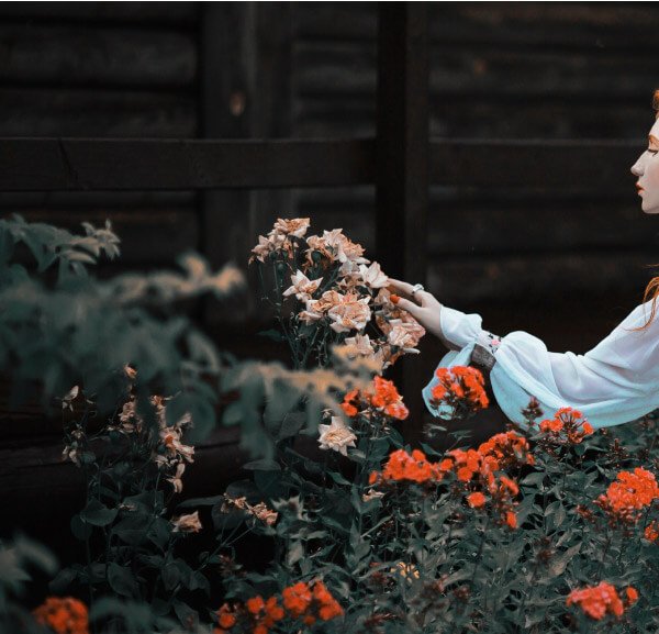 A woman is touching the flowers.