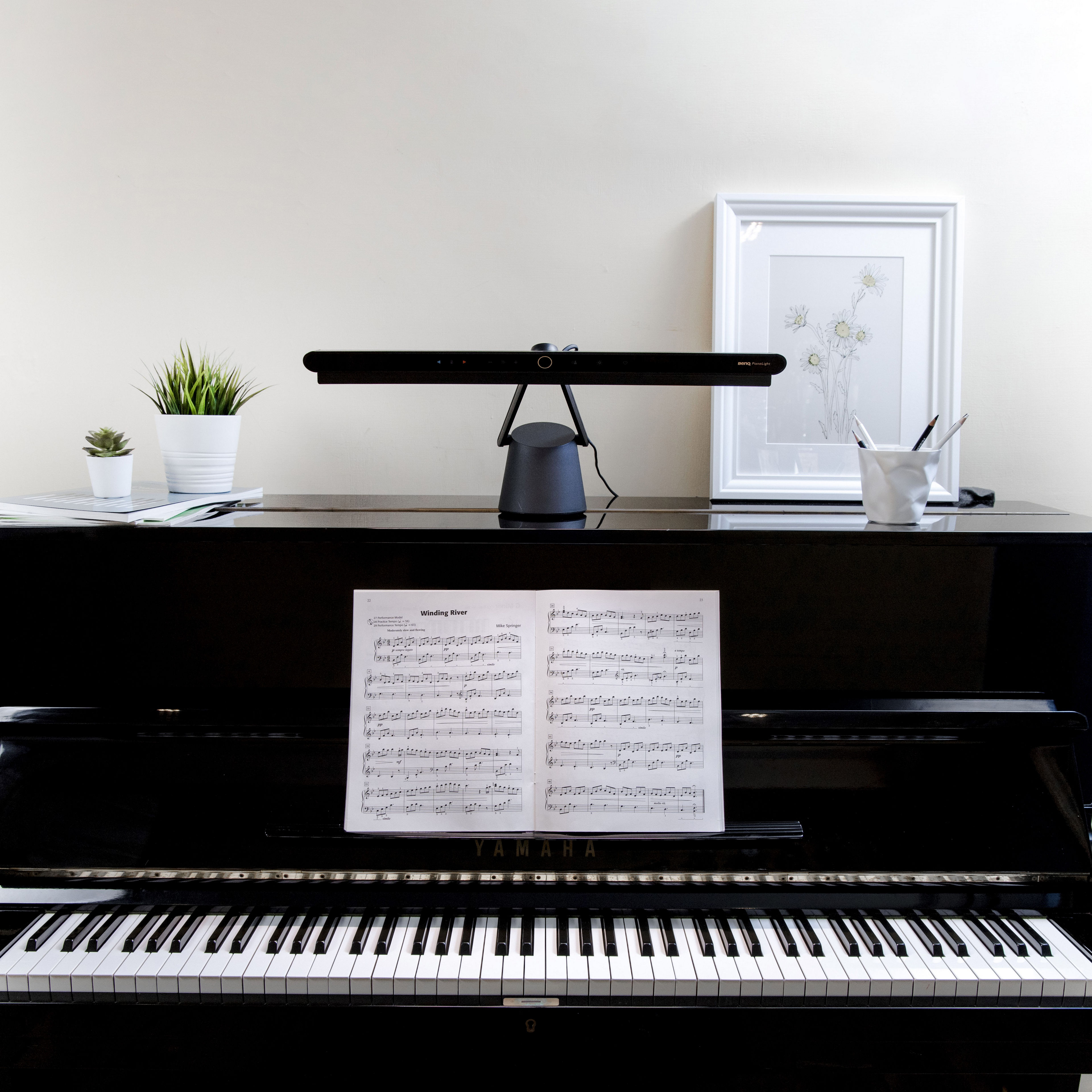 upright piano lamp placing on top of an upright piano