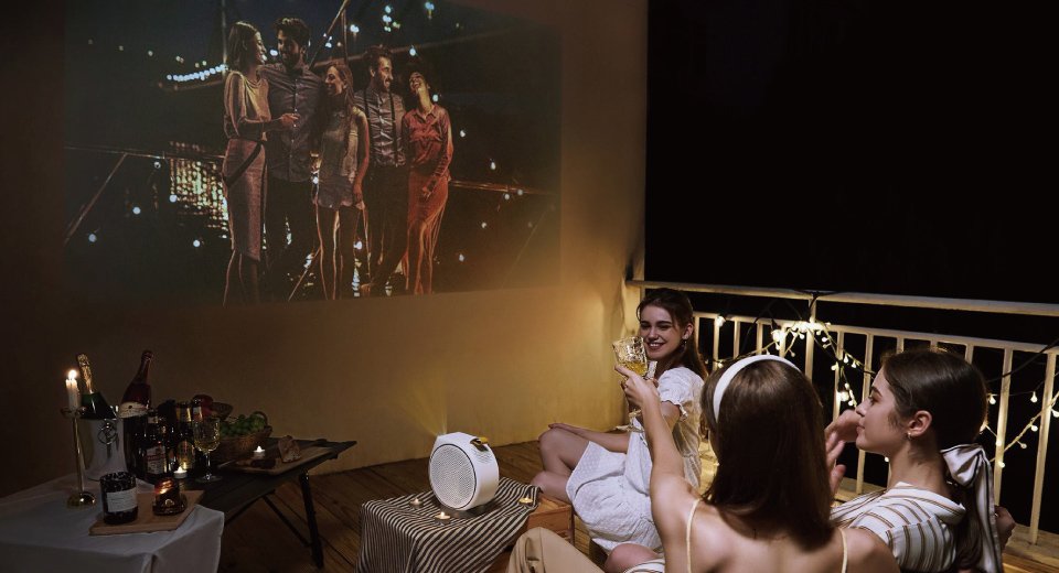 Le plaisir du cinéma lors d'une fête sur un toit avec un projecteur portable BenQ.