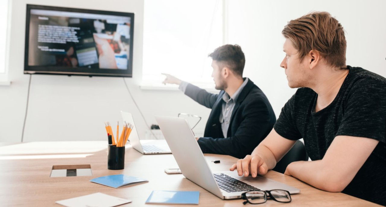 They are using laptop to wirelessly stream content to a TV in a meeting room.