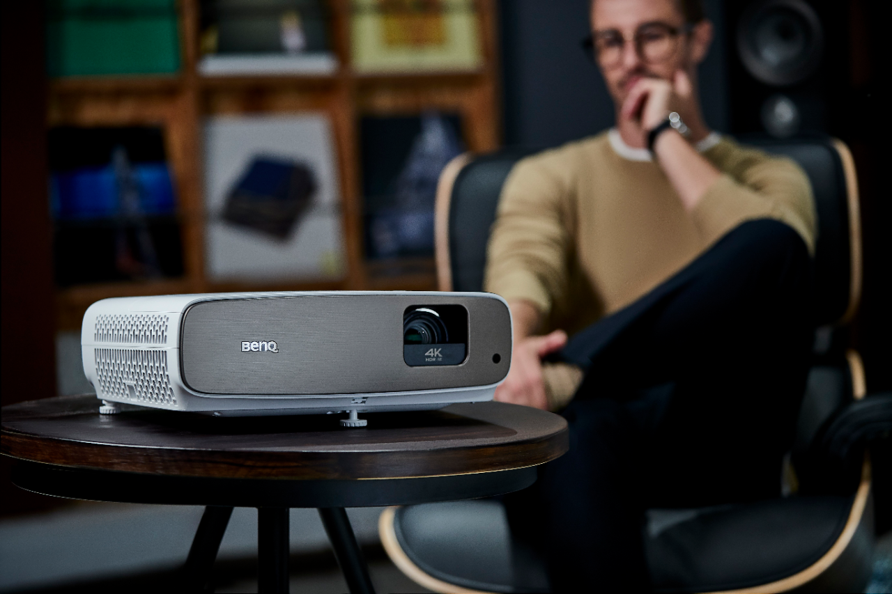 The man is enjoying cinematic viewing experiences  via 4K projector with nearly no noise.