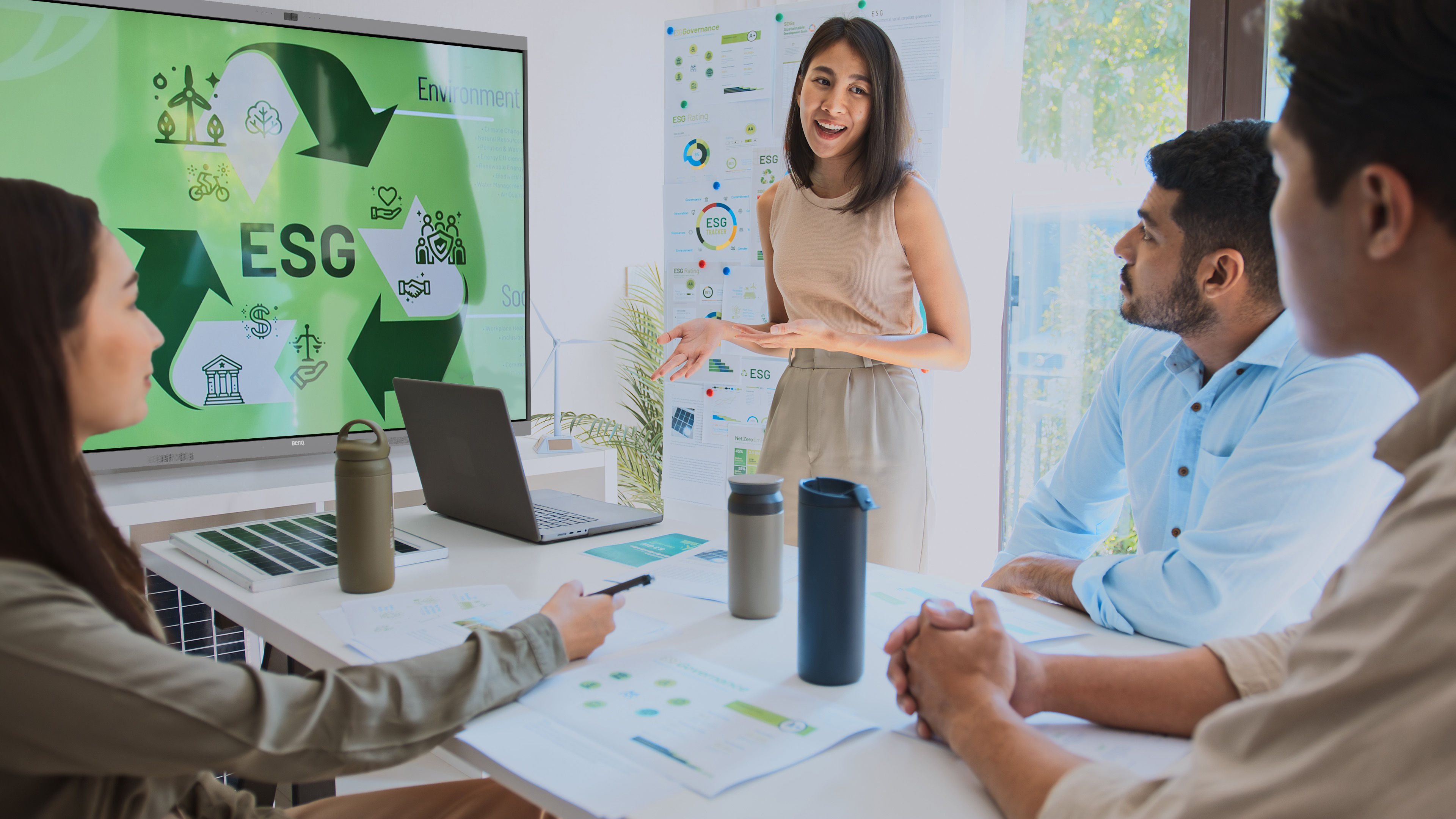 A sun-lit open layout office with a view of nature outside. The RE04FV2 is in the center of the room. Its wallpaper also shows nature.