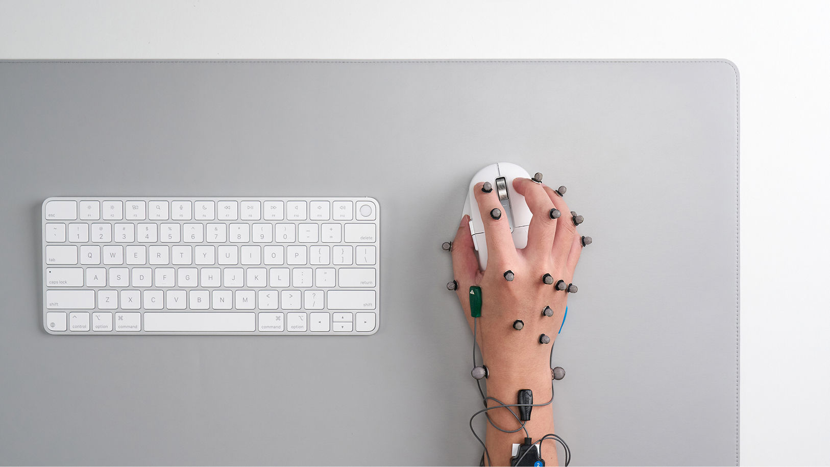 Human data capture showing motion capture and EMG sensors measuring hand, wrist, and forearm load during mouse use.