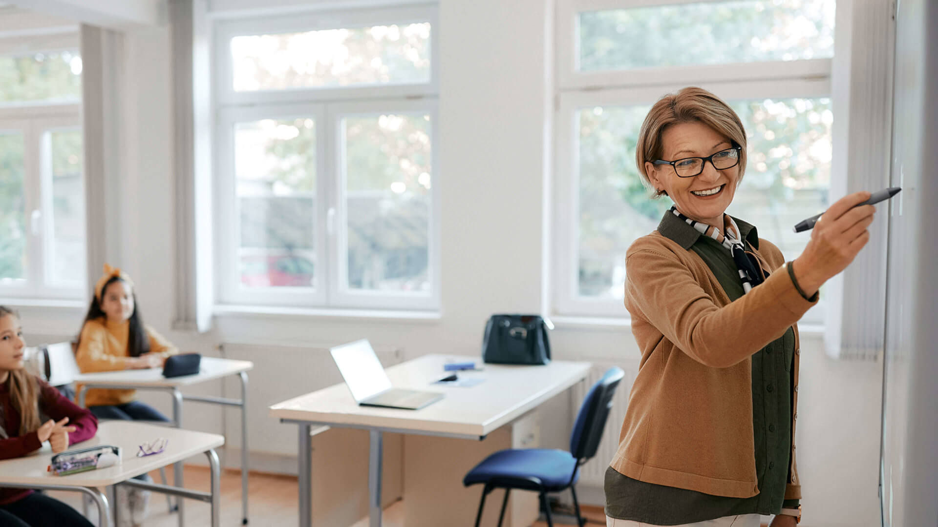 Lehrerin schreibt an interaktive Tafel