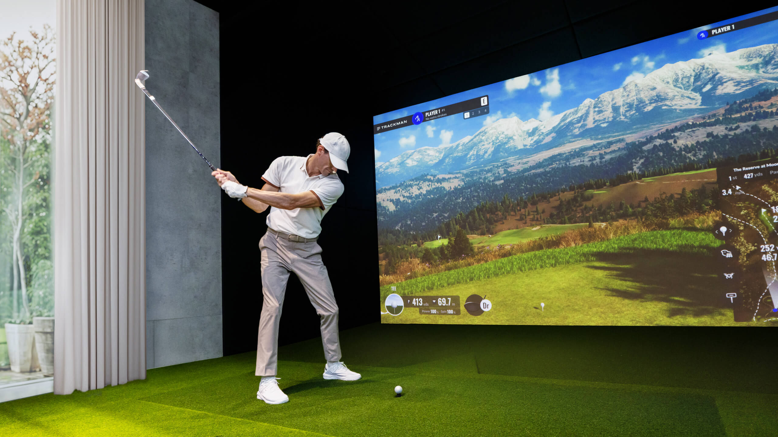 BenQ LK936ST 4K golf simulator projector in home golf sim room with bright 200-inch golf simulator screen lights on daytime setup