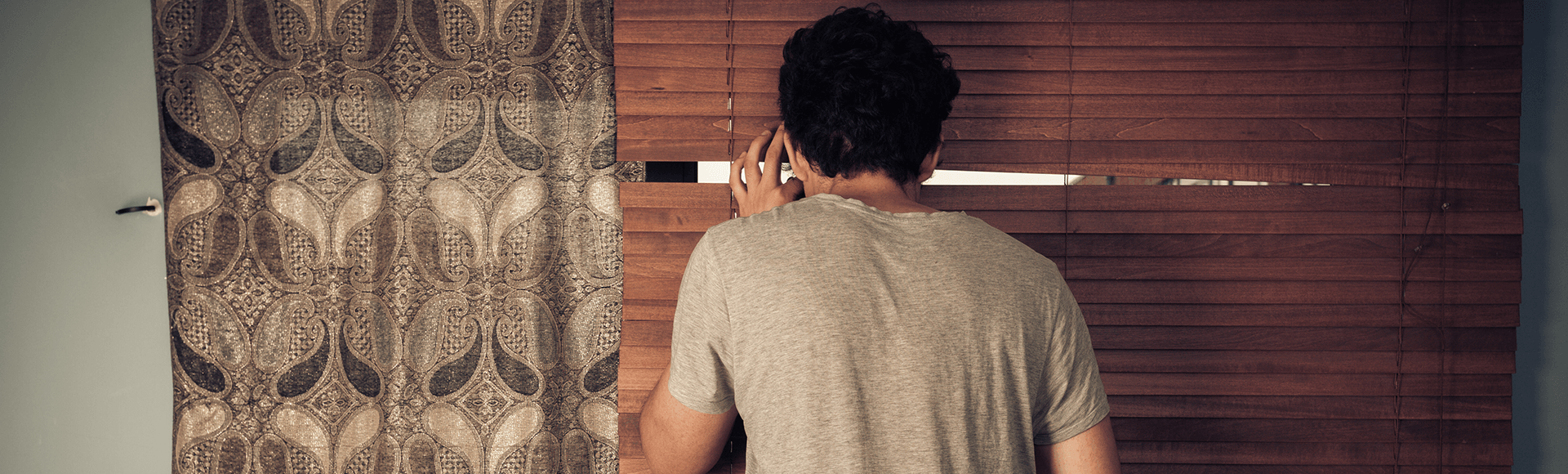 Man looking out blinds