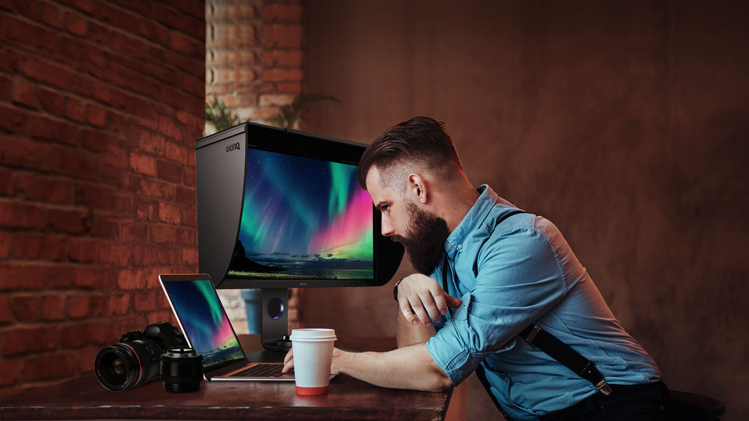 The photographer is examining, editing and communicating his work via onscreen images.