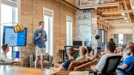 A group of people in a huddle room for a presentation using the wireless system