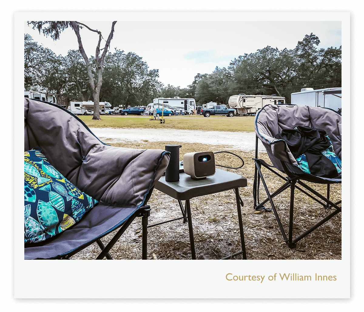 BenQ GS2 portable projector in a campground  area between two camping chairs 