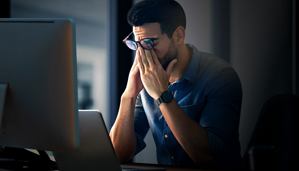 The programmer is experiencing eye strain during long coding sessions on the computer.