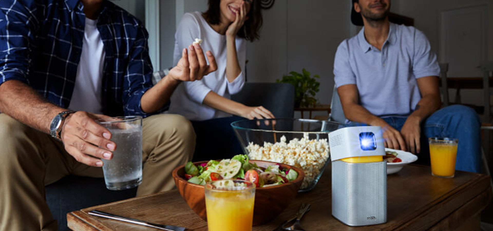 Group of friends uses portable projector during the party