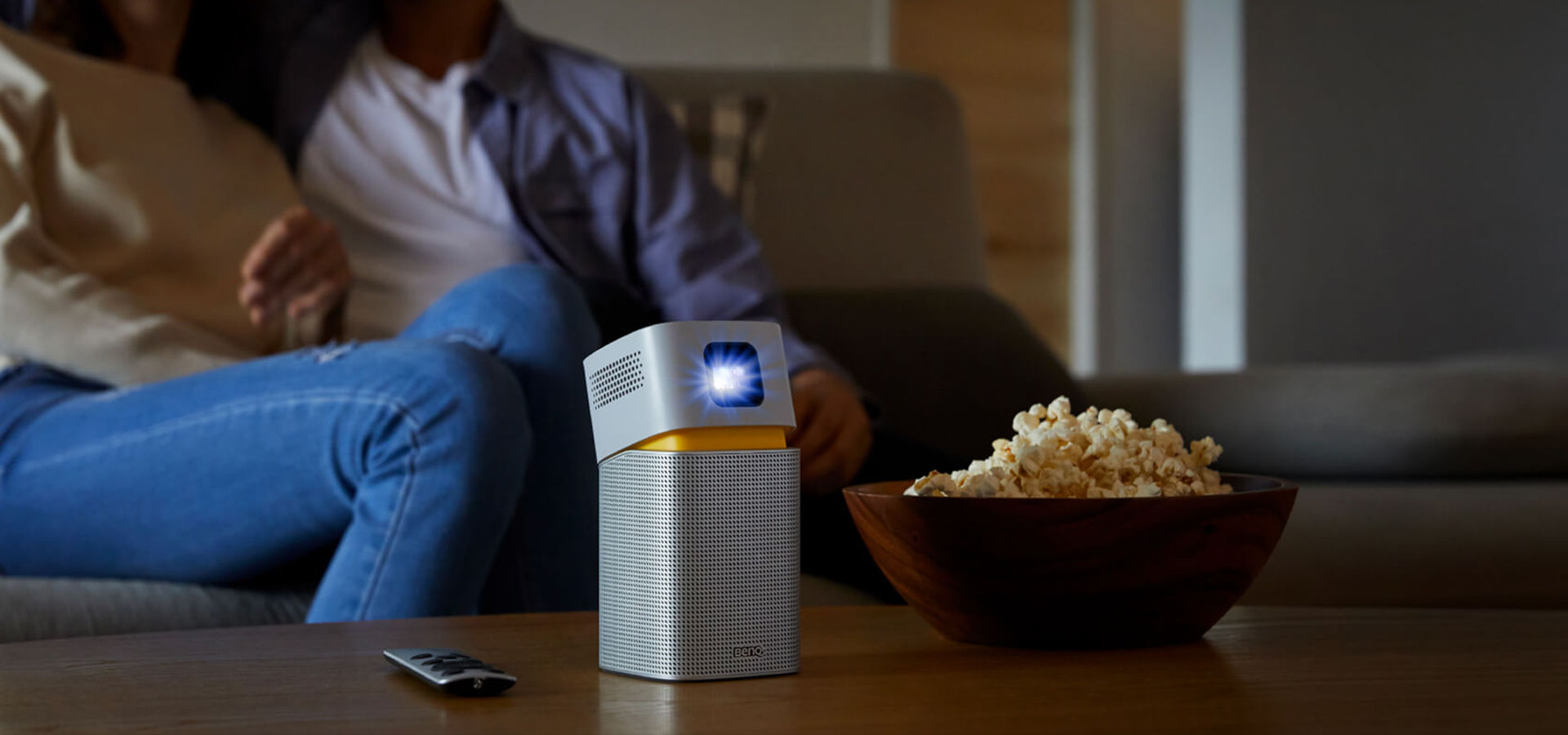 Portable projector on the table with a couple sitting behind it