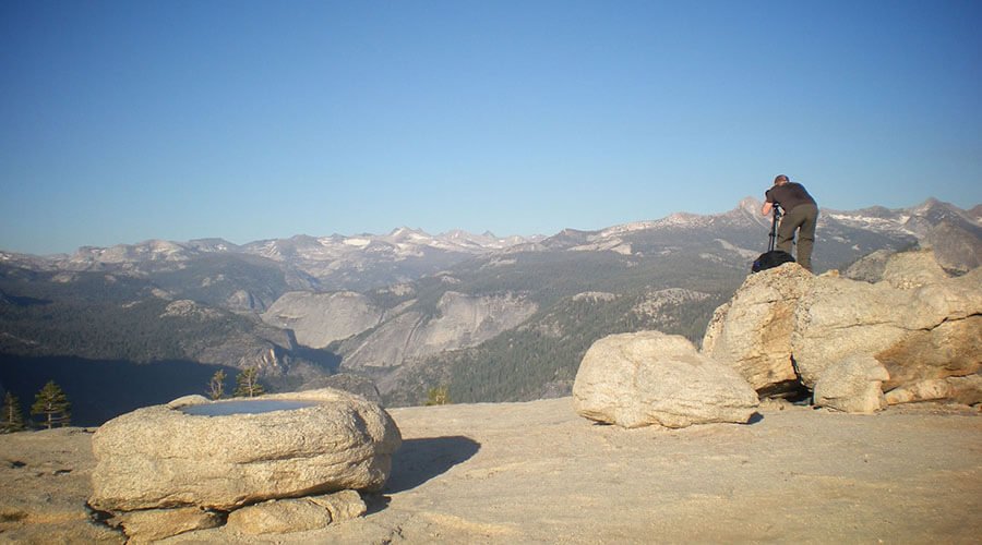A photographer is taking photo graphs in Yosemite National Park, USA.